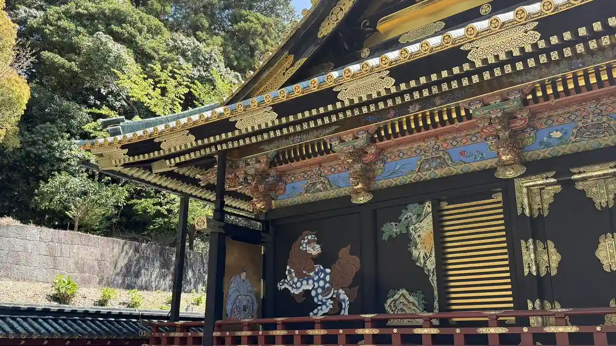 Painted human figures on black lacquered fittings below brightly coloured decoration at Kunozan Toshogu