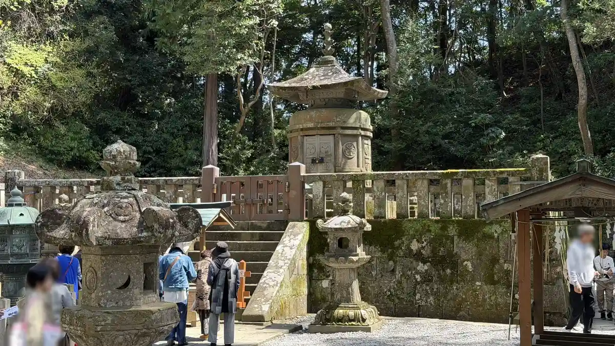 The stone pagoda marking Tokugawa Ieyasu's grave at Kunozan Toshogu, surrounded by stone lanterns (image edited to obscure a person)