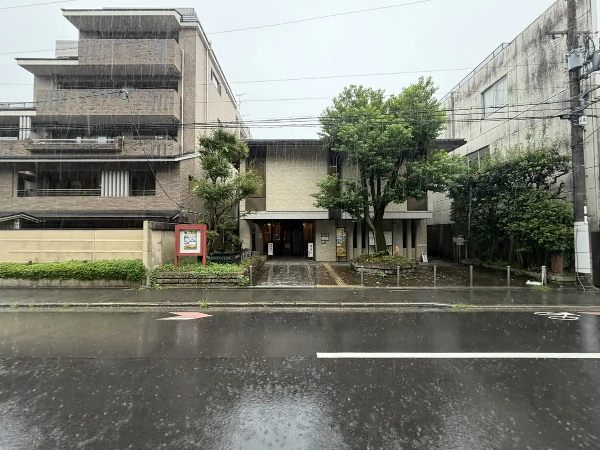通りの向かい側から見た雨の日の京都市歴史資料館の全景