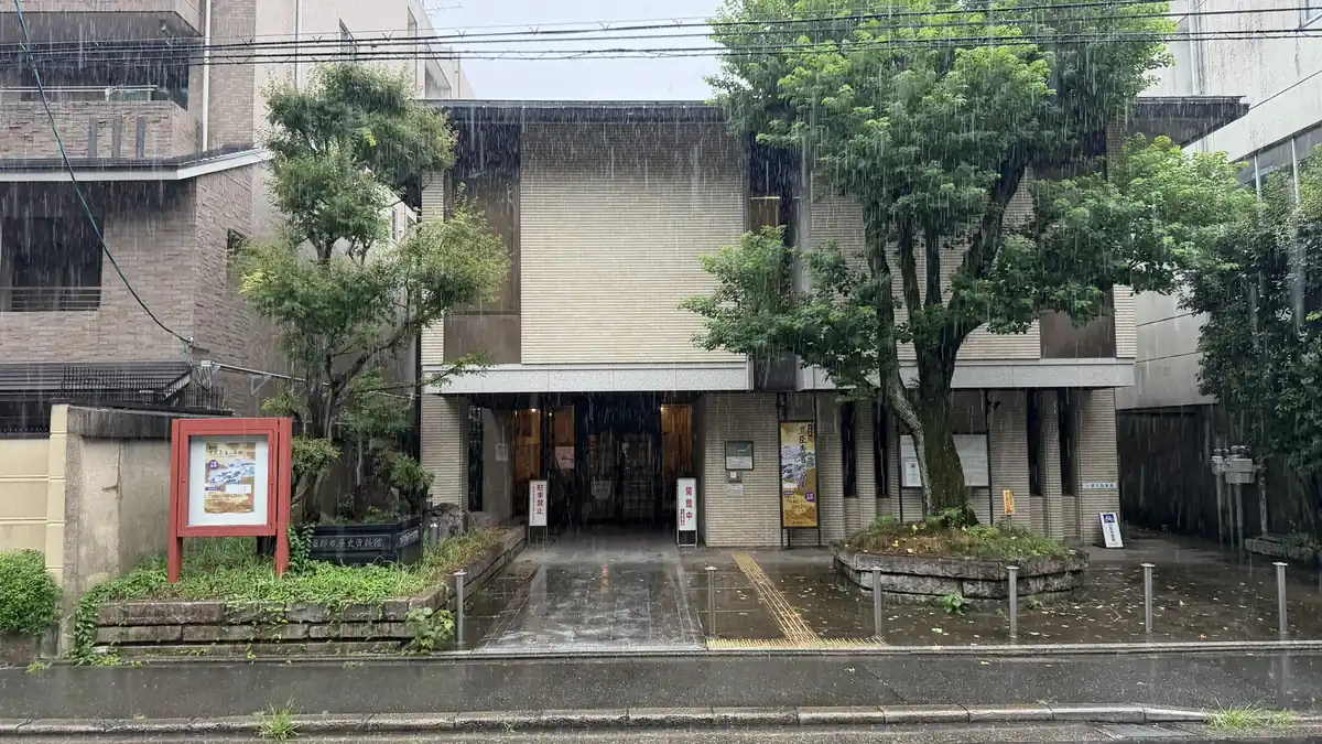 雨の中、正面から見た京都市歴史資料館の入口と外観