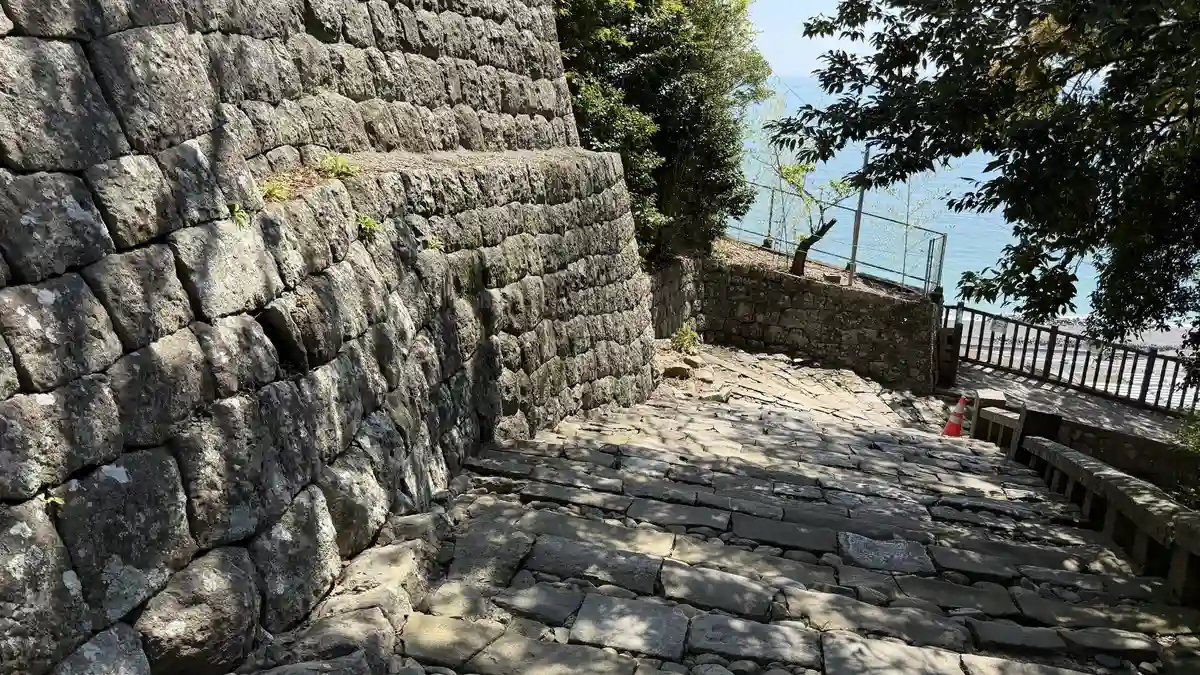 Stone steps at Kunozan running alongside high stone walling and a safety railing