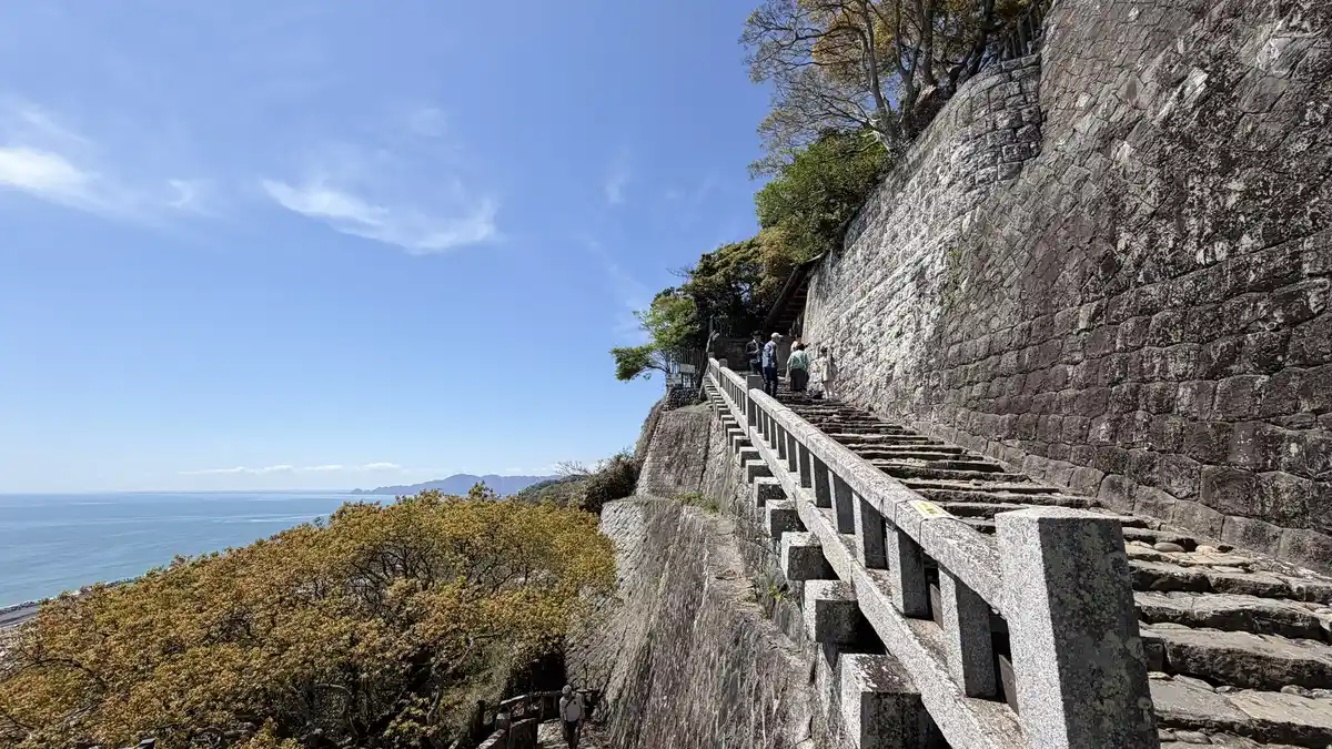 The stairway at Kunozan Toshogu running beside stone walling and a wooden handrail