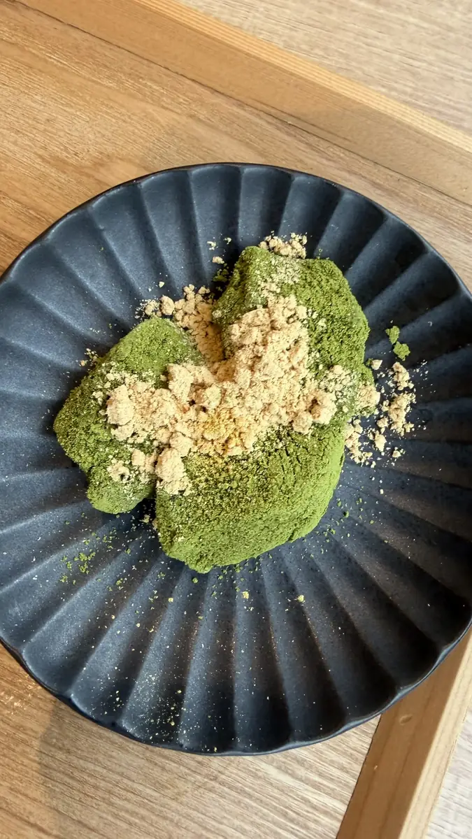 抹茶色のわらび餅にきな粉を添えた甘味