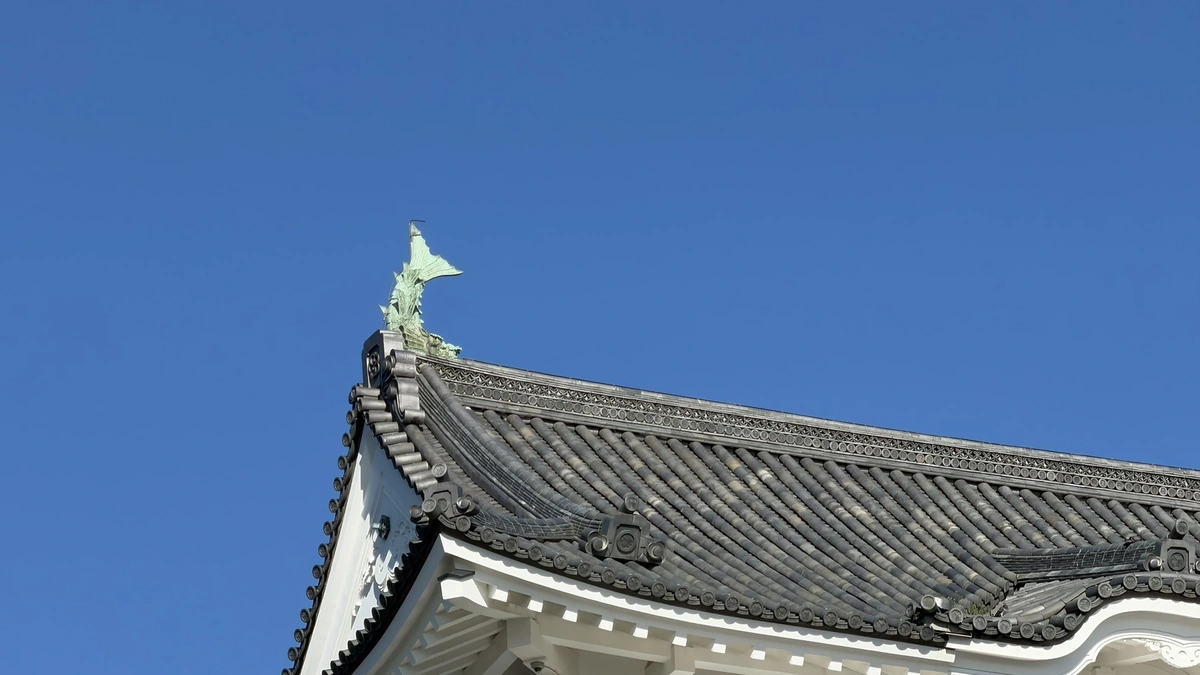 Close-up of the green shachihoko ornament on the keep's roof ridge