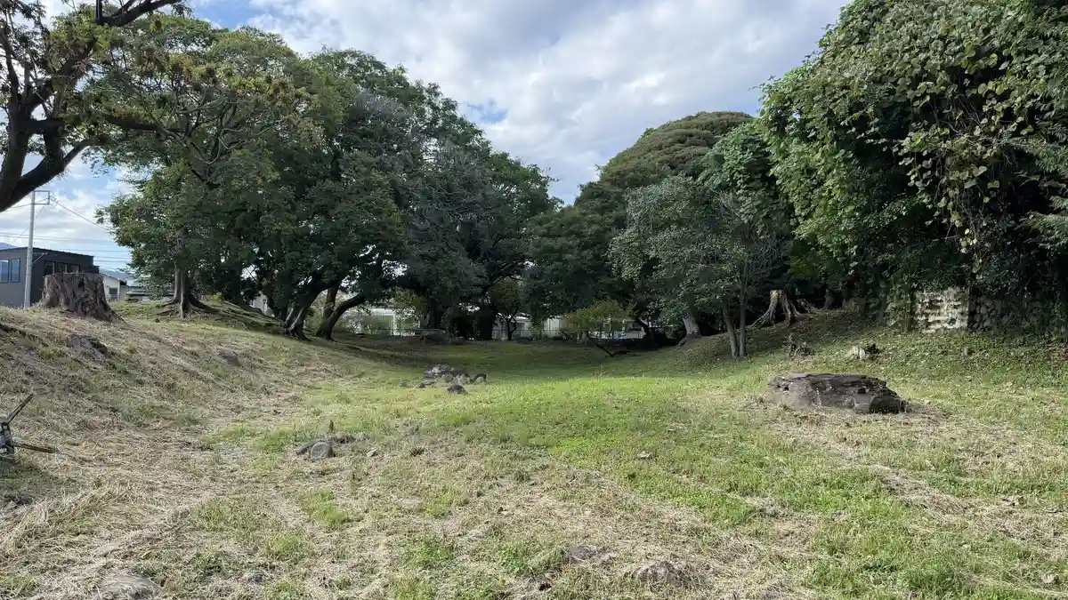 Sunken moat and tree-covered rampart of the Hayakawaguchi remains among houses