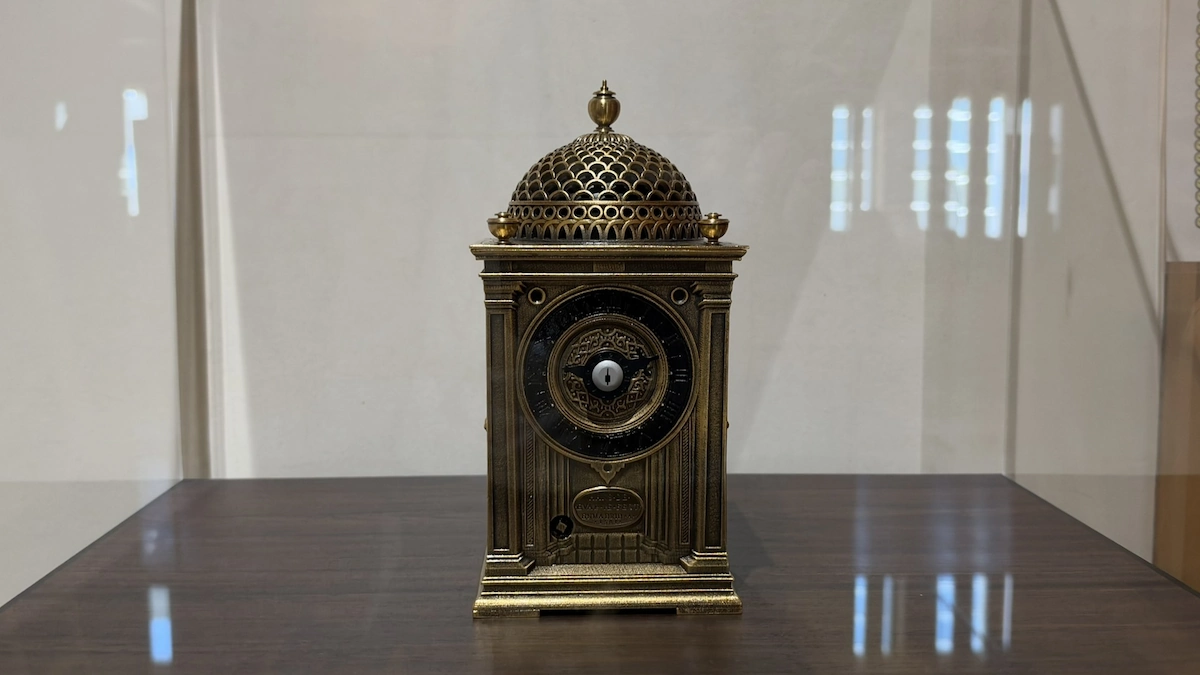 Reproduction of a table clock in Hitsujisaru Turret, Sunpu Castle Park, seen from the front: a small gold-colored clock under a domed, openwork roof