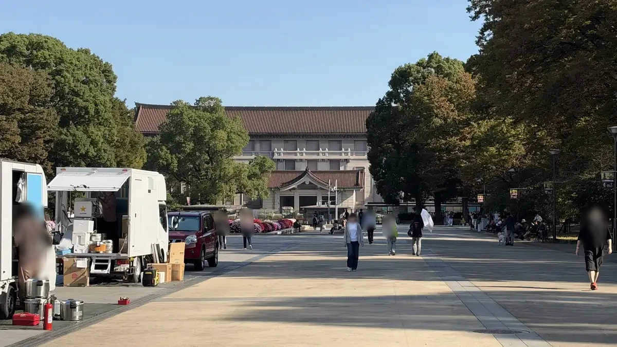 The Tokyo National Museum’s Honkan at the end of a park avenue, with food trucks on the left