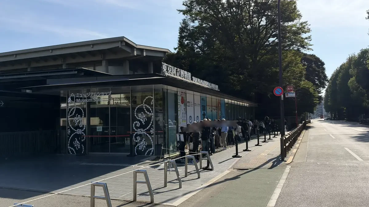 Visitors queue beside the museum shop windows before the Tokyo National Museum opens