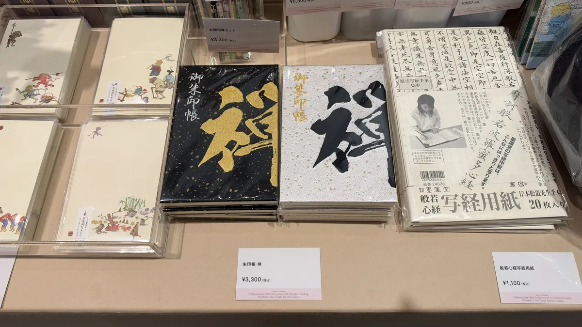 Black and white stamp books bearing the character for Zen, beside Heart Sutra copying paper