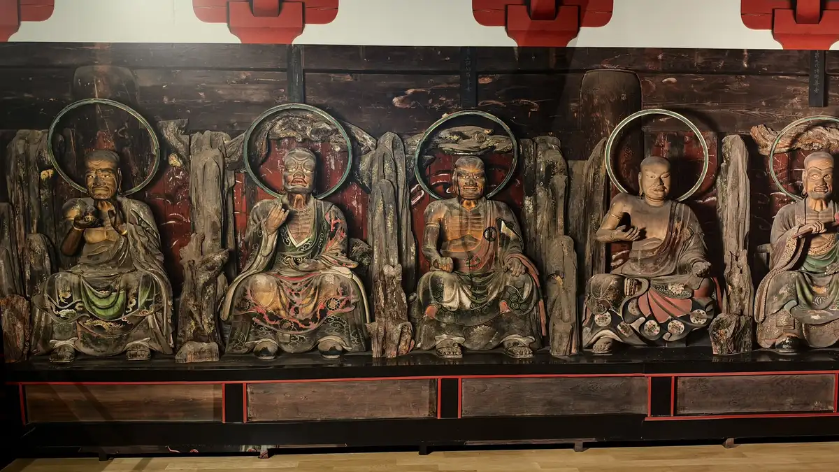 A large photographic backdrop showing seated arhats in the Daitokuji gate recreation