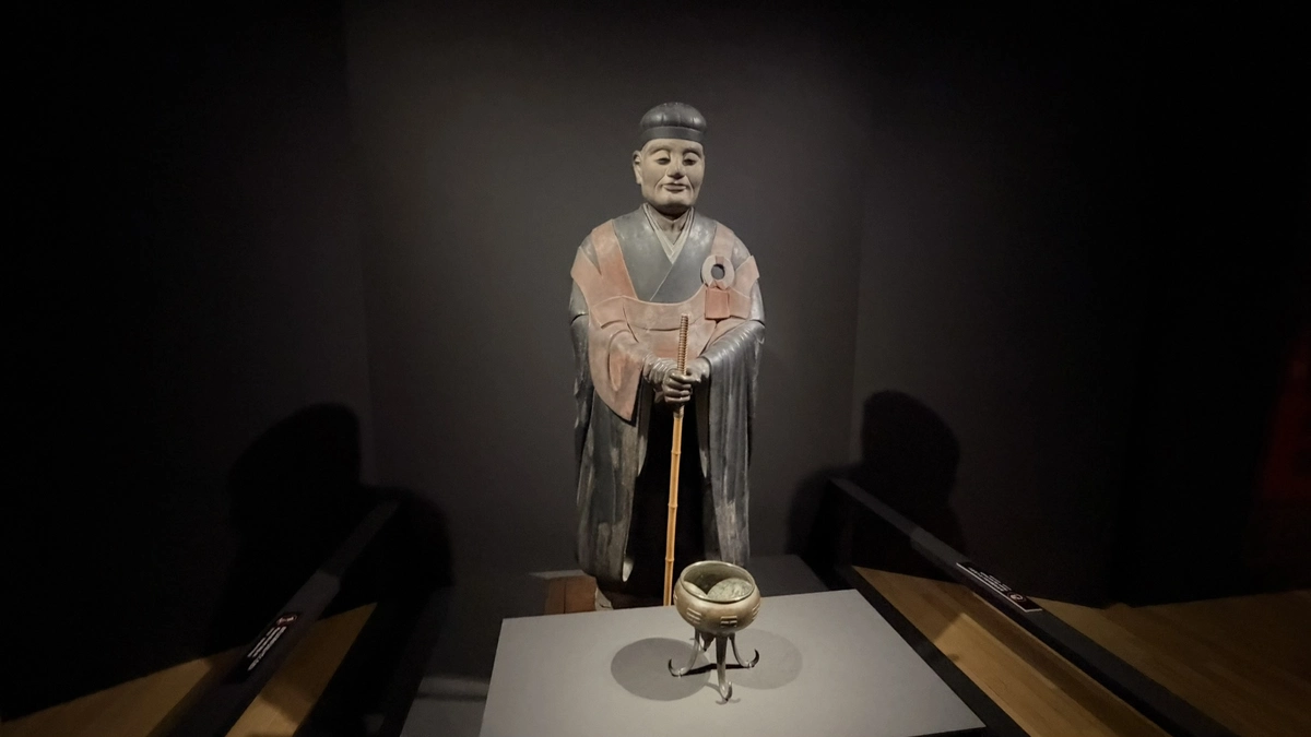 The standing statue of Sen no Rikyu holding a staff, with an incense burner in front