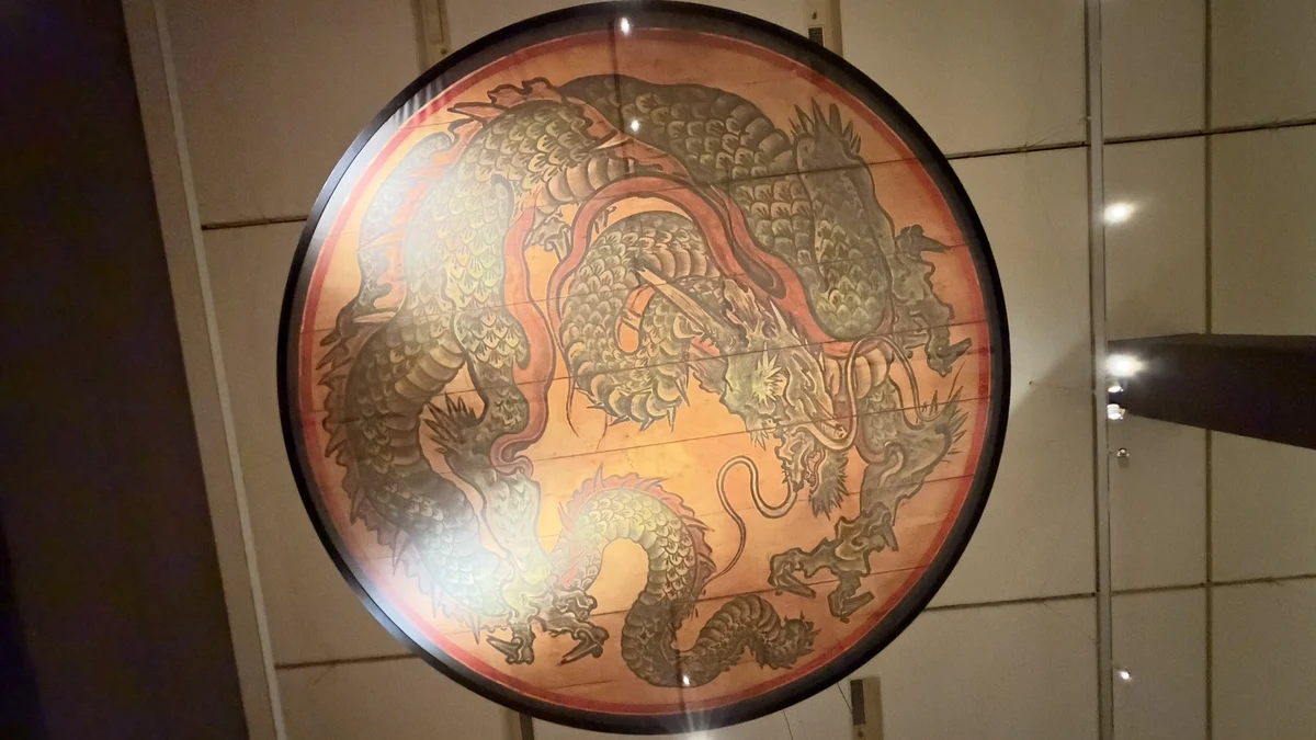 The full circular dragon-ceiling reproduction, with reflections along its left side
