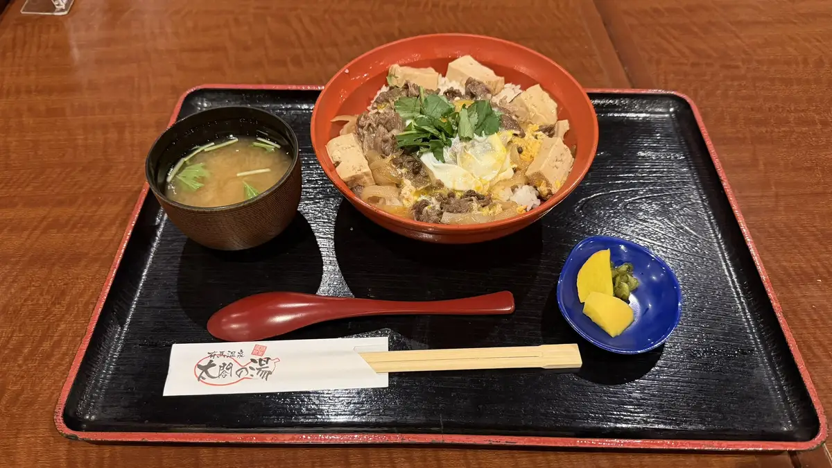 The beef and Awaji onion simmered in egg at Taiko no Yu's food court, served as a rice bowl with soup and pickles.