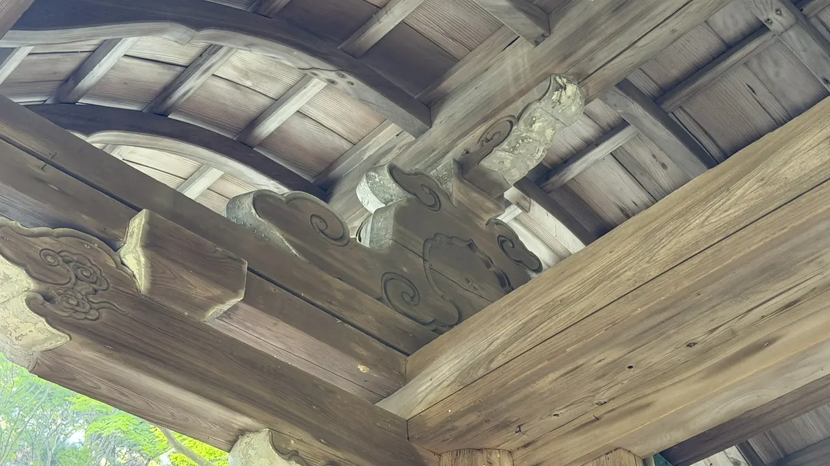 Thick beams and joinery under the eaves of the gate.
