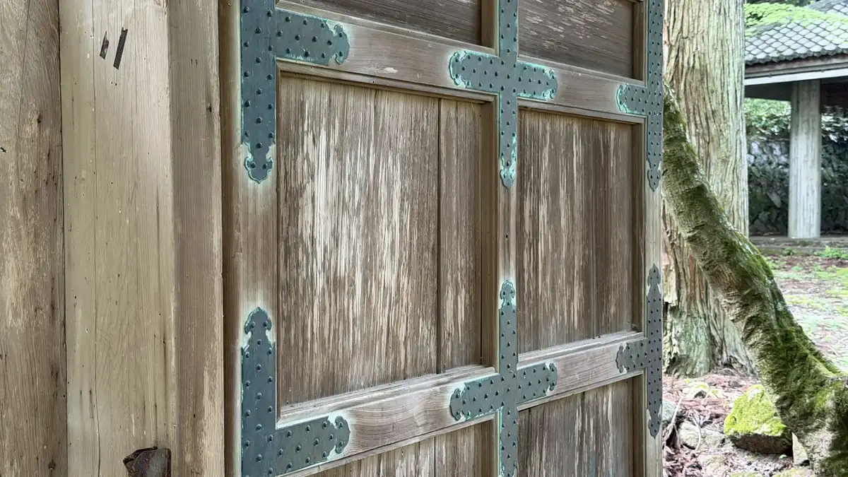 A wooden door with metal fittings, seen up close.
