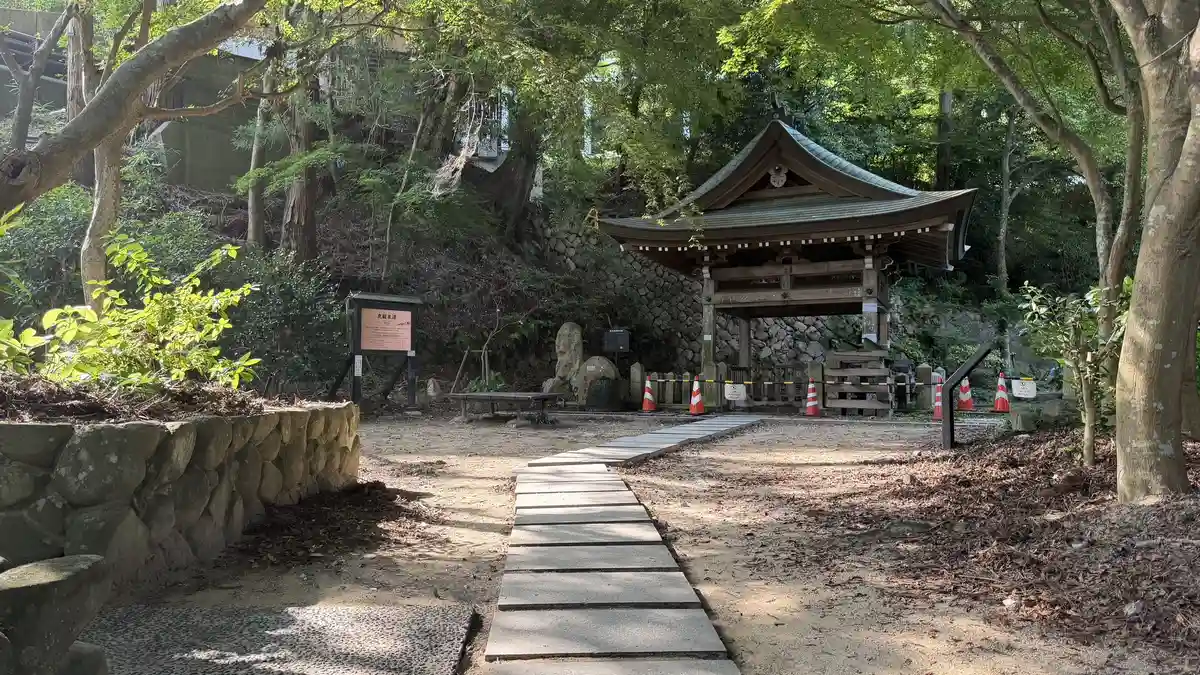 The plaza at Tansan Spring: a spring house and stone paving among trees.