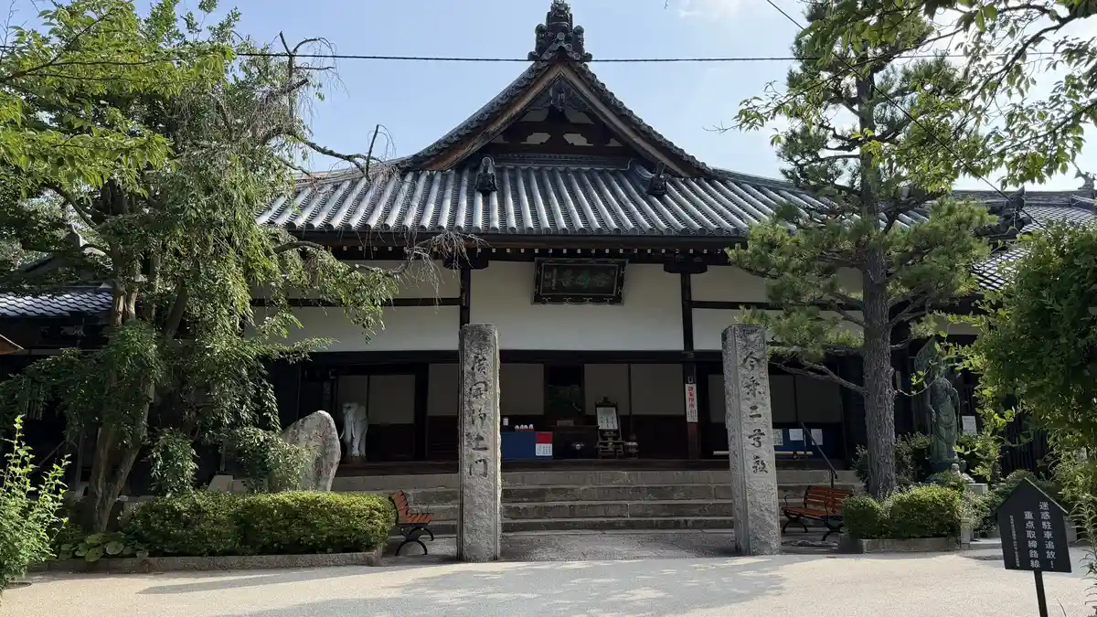 The main hall of Nenbutsuji, with a stone pillar at the gate.