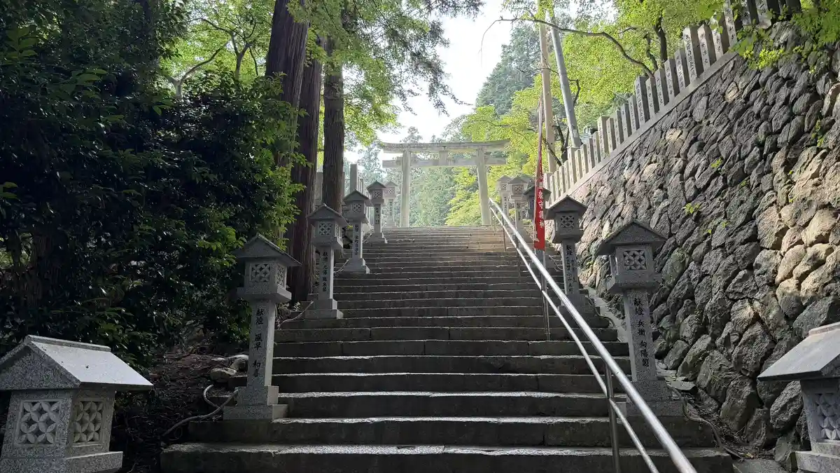 The approach: stairs beside a stone wall, with the torii gate ahead.