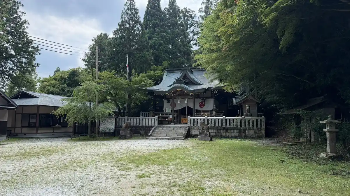 The main building of Yusen Shrine, among trees and a fence.