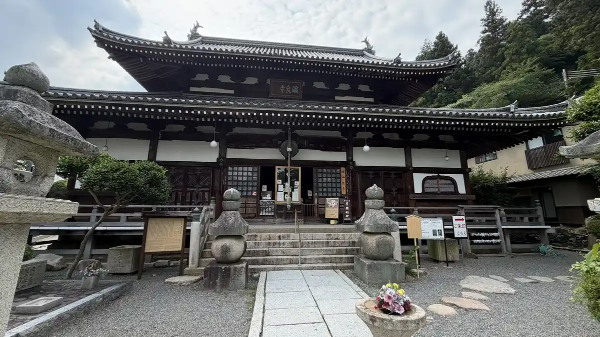 The main hall of Onsen-ji, with a large roof and stone lanterns.