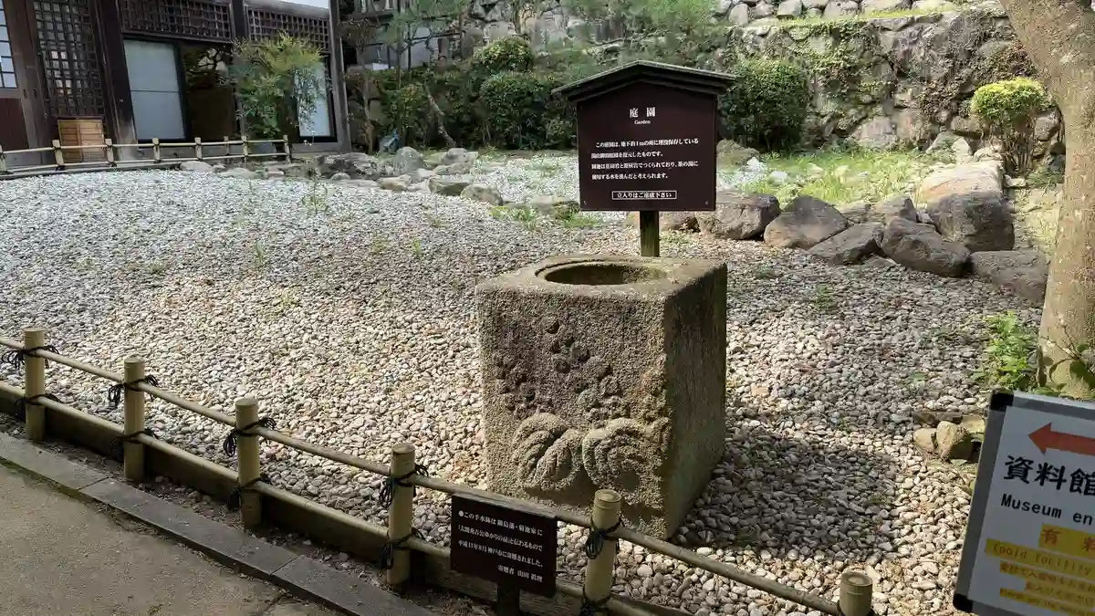 The museum garden: stonework, gravel and a stone water basin.