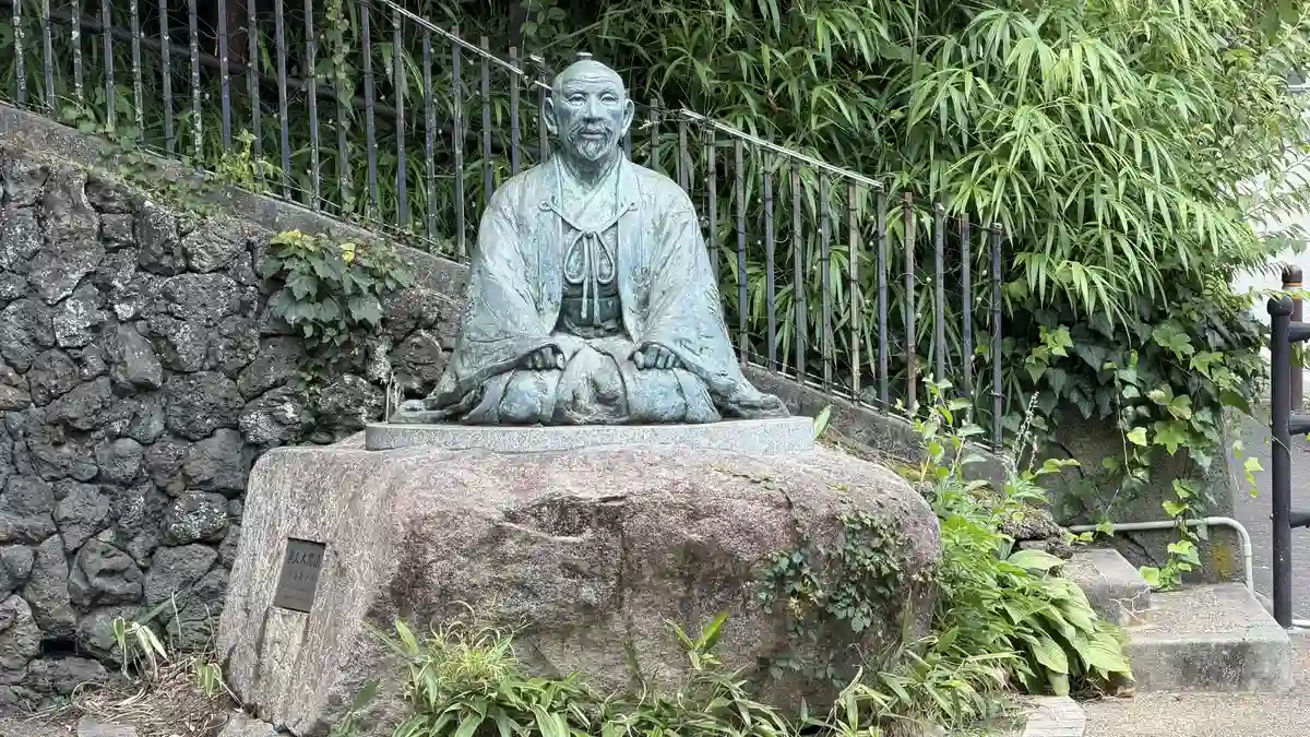 The Hideyoshi statue seated on a rock base, seen from close to the front.