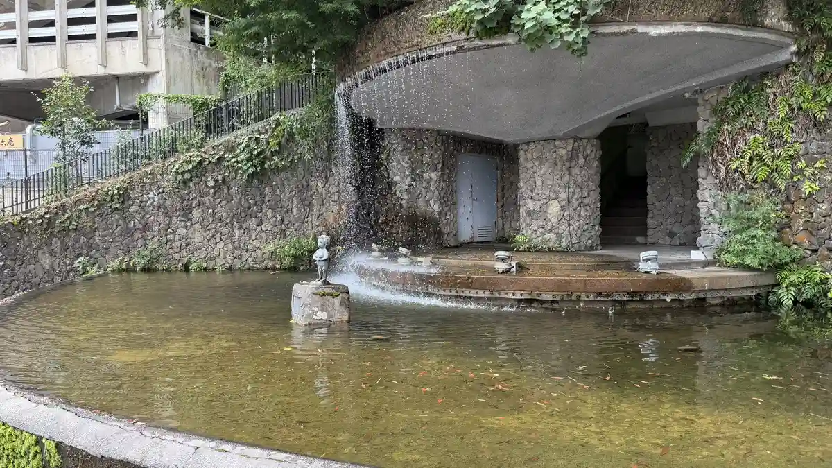 The waterfall in Yukemuri Square, falling into a pond beneath a round roof.