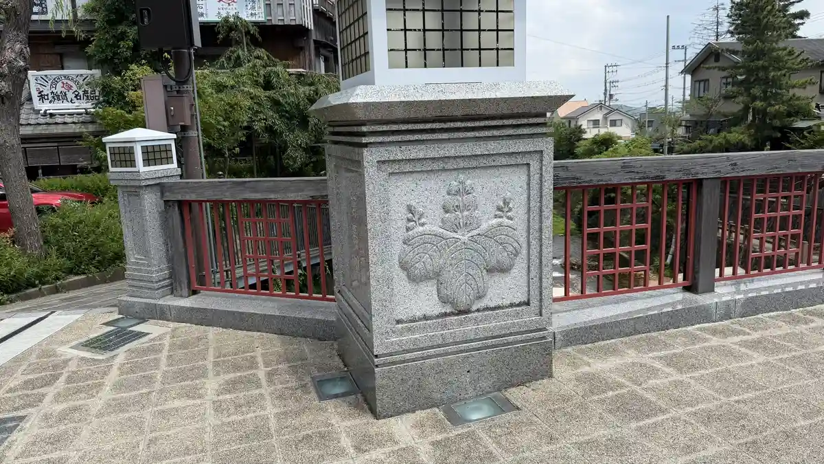 Detail of Taiko Bridge: the Toyotomi crest carved on the pillar, and the red railing.
